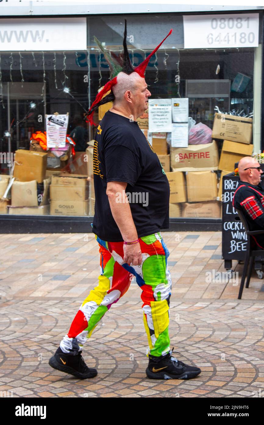 The punk subculture, ideologies, fashion, with Mohican dyed hairstyles and colouring at the 2022 Punk Rebellion festival at The Winter Gardens, Blackpool, UK. A protest against conventional attitudes and behaviour, a clash of anti-establishment cultures,  mohawks, safety pins and a load of attitude at the seaside town as punks attending the annual Rebellion rock music festival at the Winter Gardens come shoulder to shoulder with traditional holidaymakers. Stock Photo