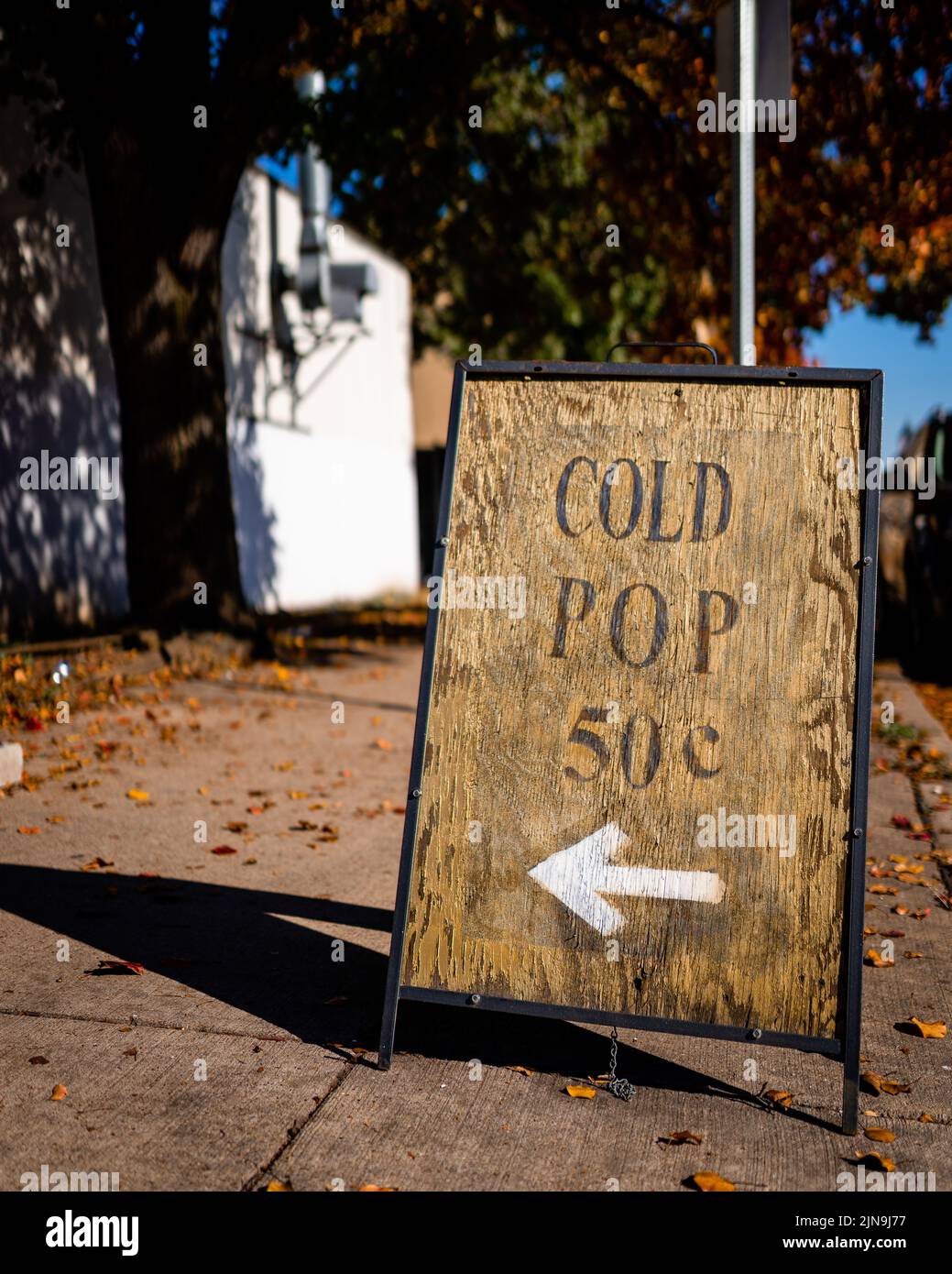 A closeup of an outdoor wooden pavement sign displaying a direction, a ...