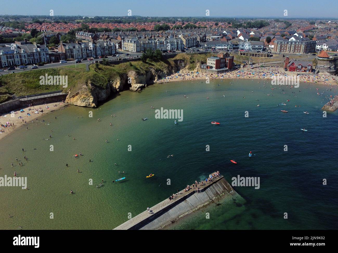 An aerial view of people enjoying the hot weather on the beach at Cullercoats Bay in North Tyneside. The Met Office has issued an amber warning for extreme heat covering four days from Thursday to Sunday for parts of England and Wales as a new heatwave looms. Picture date: Wednesday August 10, 2022. Stock Photo