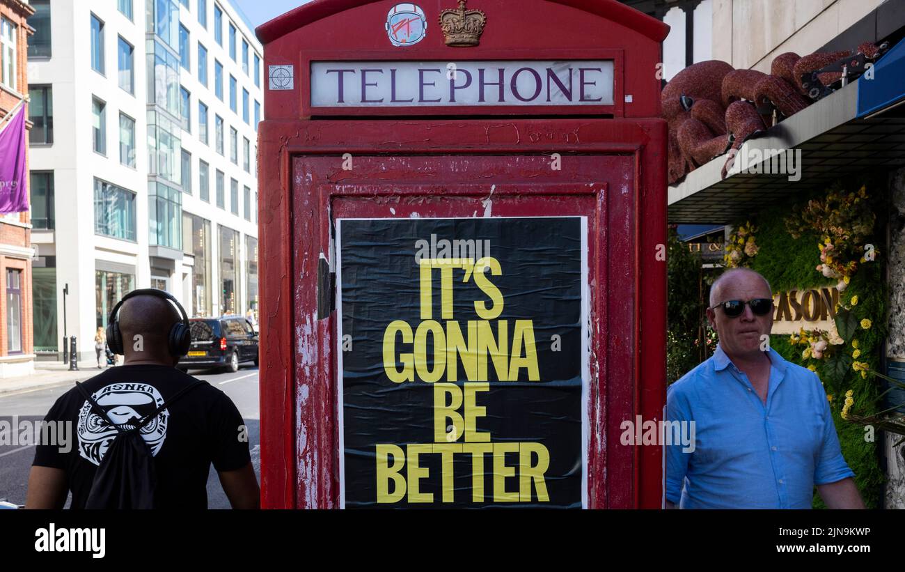 London, UK.  10 August 2022.  People walk past a telephone box in Mayfair which carries a promotional message “It’s Gonna Be Better”.  Given the UK’s current economic woes, rising inflation rate, rise in the base rate, cost of living crisis and drought conditions, some might see this as a hope for the future.  Credit: Stephen Chung / Alamy Live News Stock Photo