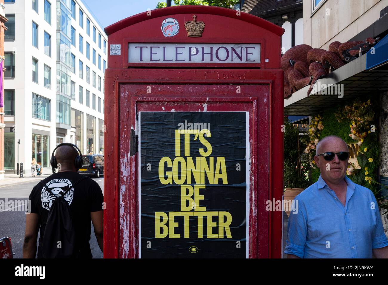 London, UK.  10 August 2022.  People walk past a telephone box in Mayfair which carries a promotional message “It’s Gonna Be Better”.  Given the UK’s current economic woes, rising inflation rate, rise in the base rate, cost of living crisis and drought conditions, some might see this as a hope for the future.  Credit: Stephen Chung / Alamy Live News Stock Photo