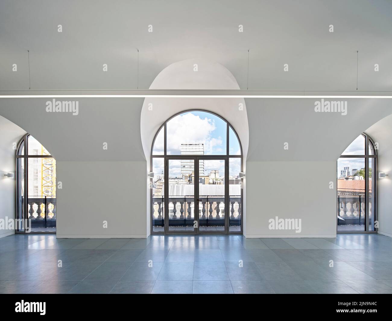 Unfurnished upper floor with arched windows and city view. 30 St James' Square, London, United Kingdom. Architect: Eric Parry Architects Ltd, 2021. Stock Photo