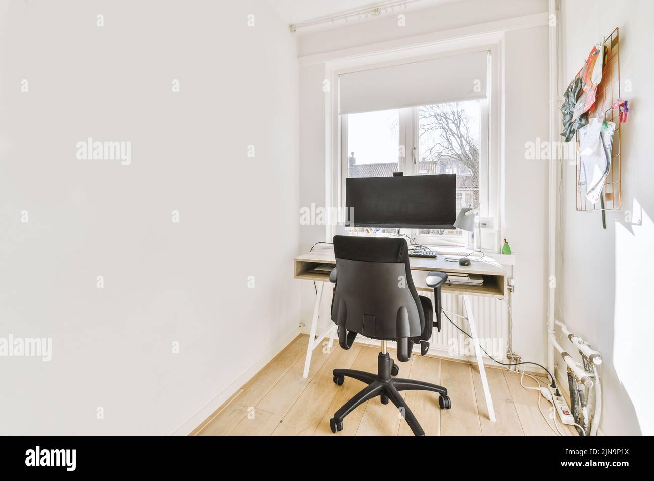 Minimalist narrow interior of study room with parquet floor and white
