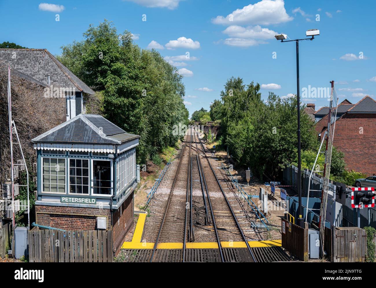 Signal box at Petersfield station along side the railway tracks and level crossing. Stock Photo
