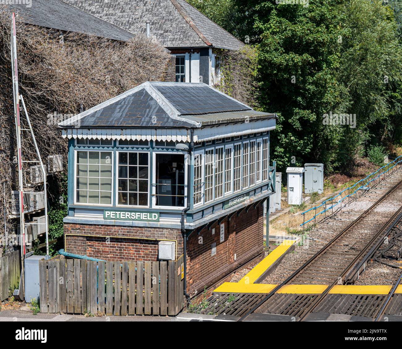 Signal box at Petersfield station along side the railway tracks and next to the level crossing. Stock Photo