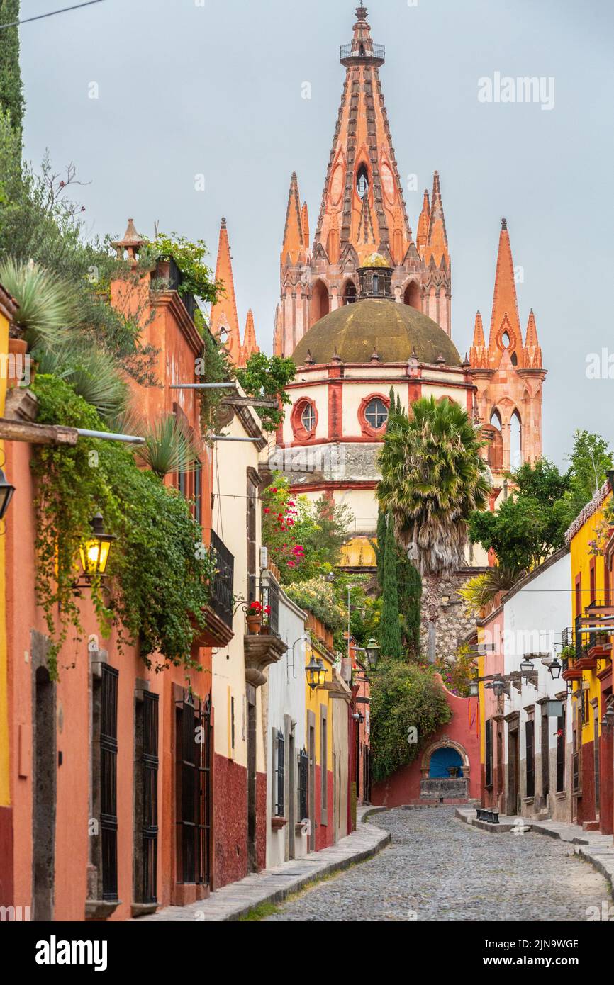 Early morning view of the cobblestone Calle Aldama and the original barque tower of Parroquia de San Miguel Arcangel in the historic city center of San Miguel de Allende, Mexico. Stock Photo