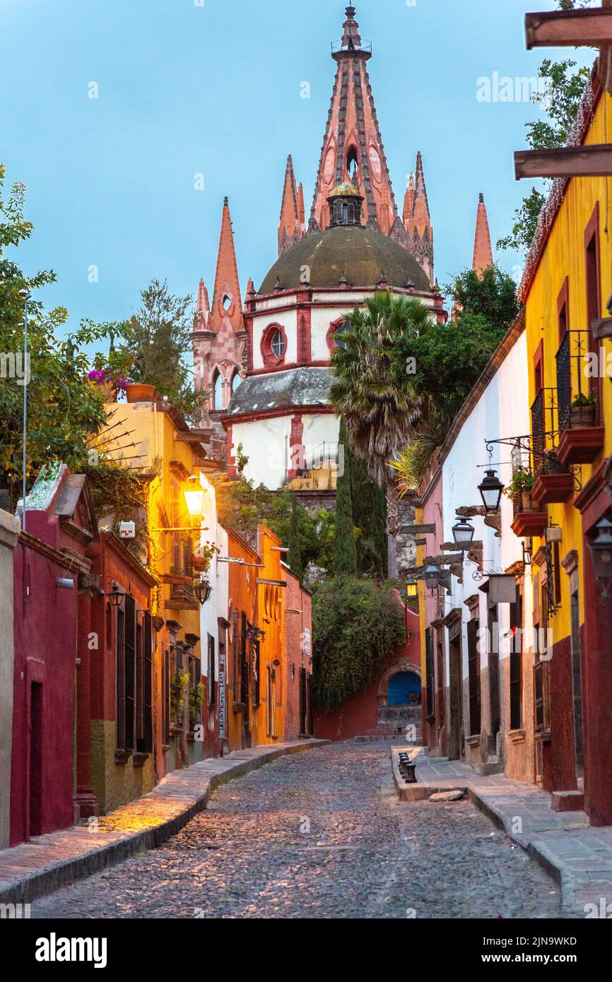 Early morning view of the cobblestone Calle Aldama of the original barque tower of Parroquia de San Miguel Arcangel in the historic city center of San Miguel de Allende, Mexico. Stock Photo