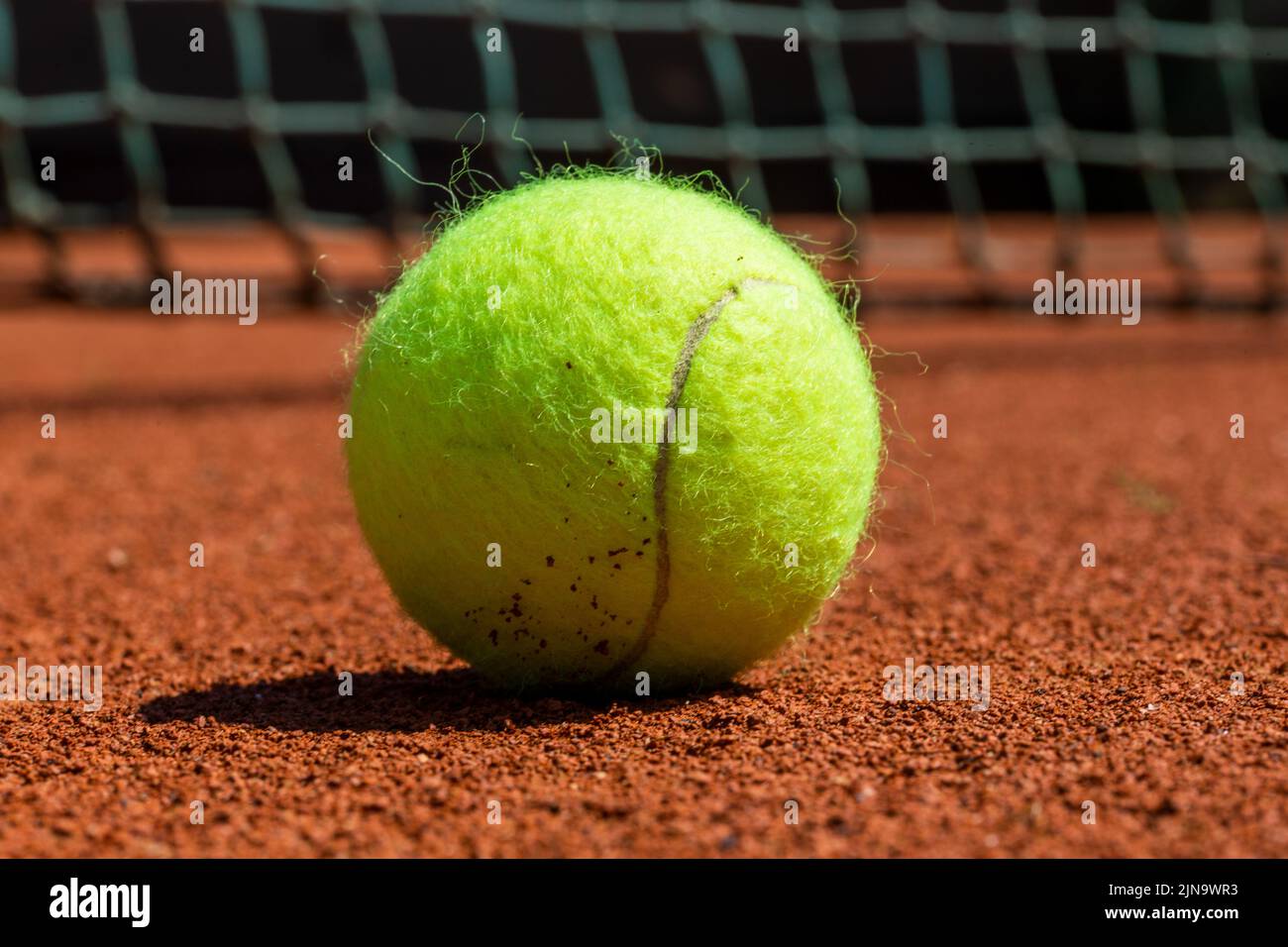 Symbol image tennis: Close-up of a tennis ball on a clay court Stock Photo