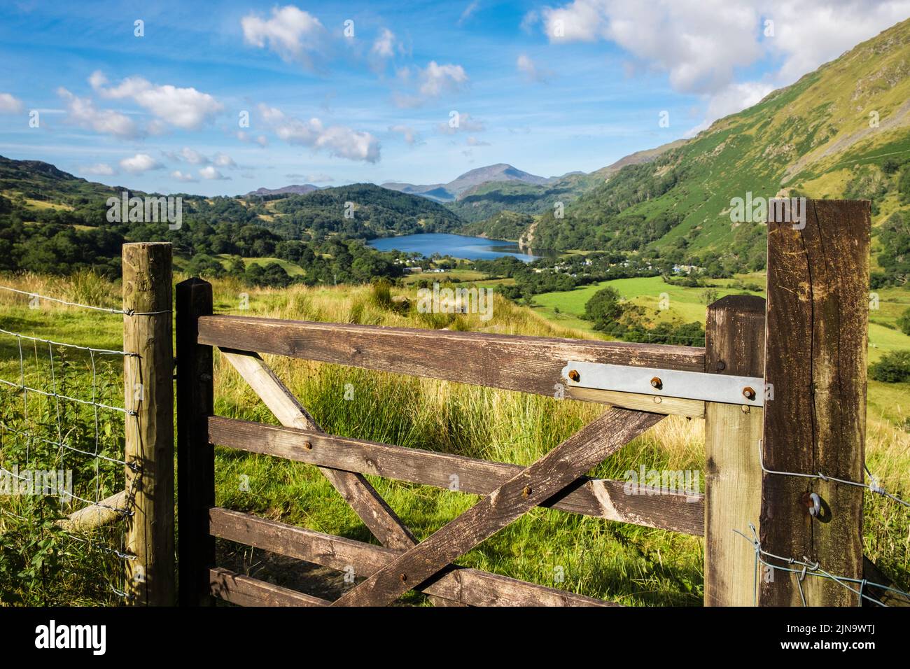 Scenic view over gate along Nant Gwynant valley to Llyn Gwynant lake and campsite in Snowdonia National Park. Nantgwynant Beddgelert Gwynedd Wales UK Stock Photo