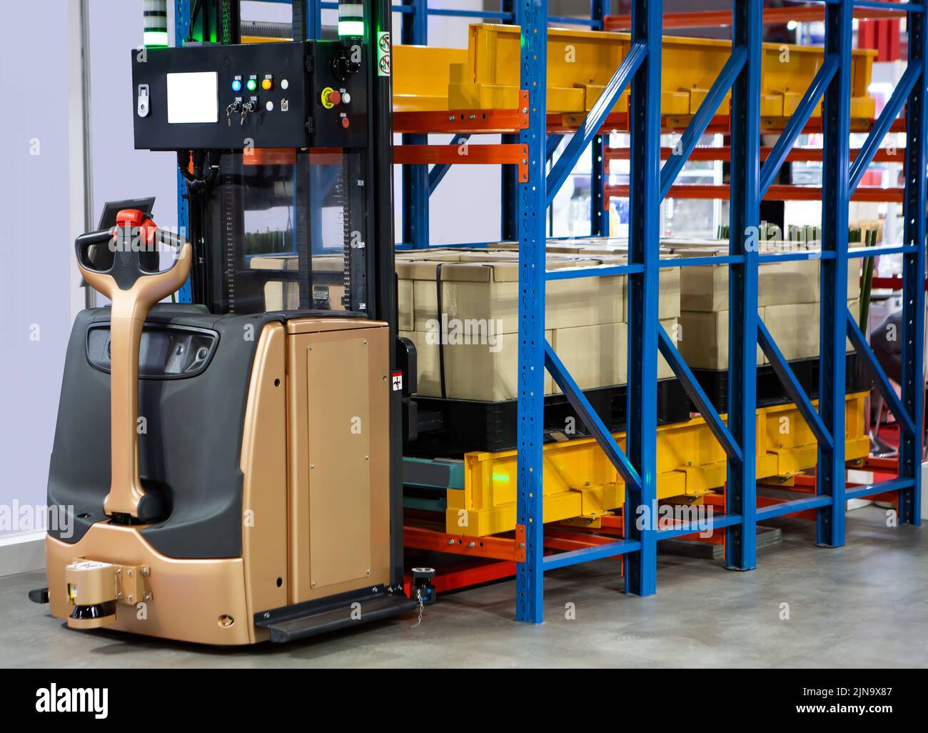Automated Guided Vehicles (AGV) forklift lifting carton in modern warehouse. Stock Photo
