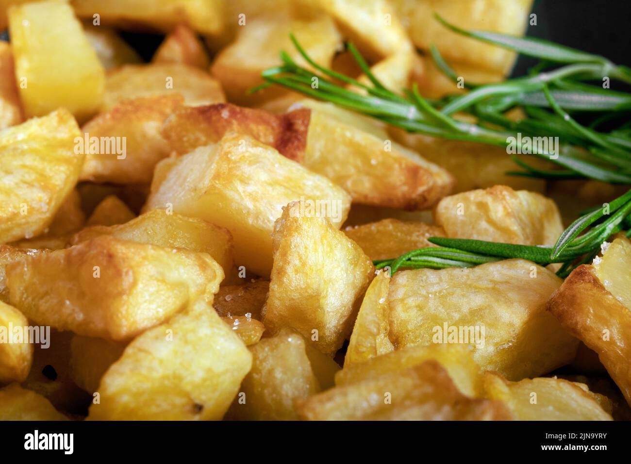 Macro close-up of homemade baked potatoes with rosemary. Stock Photo