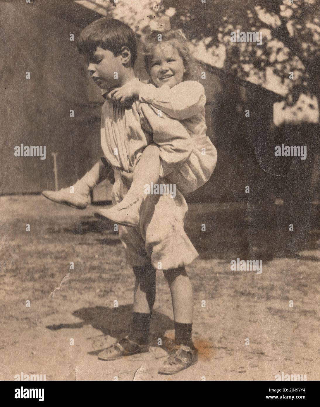 Virginia Hall, age four, is getting a piggy back ride  from her older brother John W. Hall in this1910 photograph. Johnnie, as she called him, is credited with creating his younger sister's second nickname, Dindy, by mispronouncing her first nickname which was Ginger. Dindy and Johnnie were very close their whole lives. Stock Photo