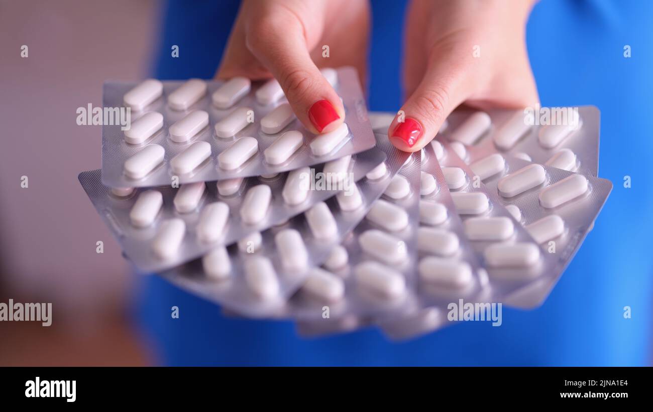 Person holds lot of pills in blister Stock Photo