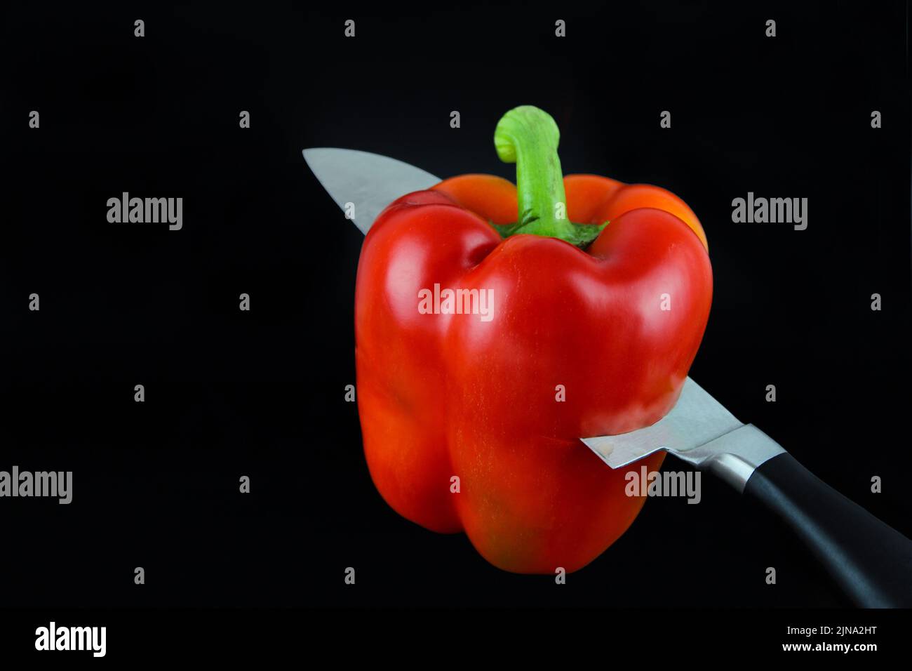Close-up of reb bell pepper which is was cut by blade of a kitchen knife. Stock Photo