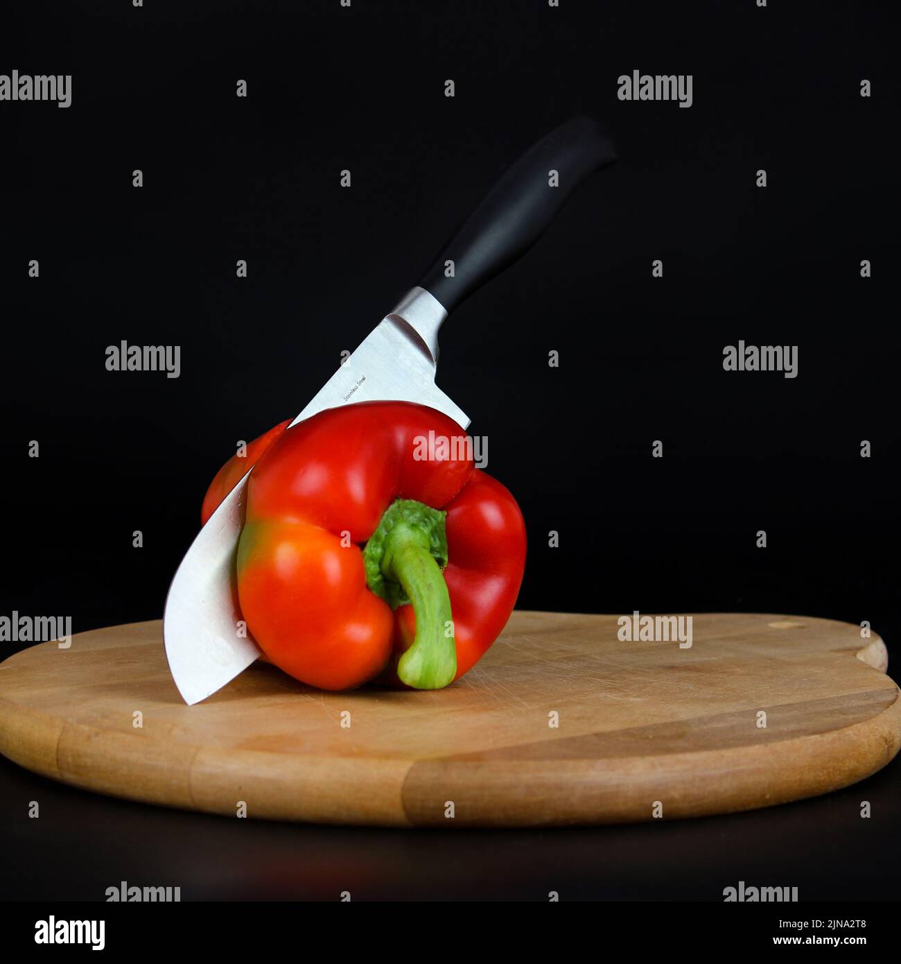 https://c8.alamy.com/comp/2JNA2T8/sharp-knife-cutting-a-red-pepper-with-a-knife-on-a-cutboard-2JNA2T8.jpg