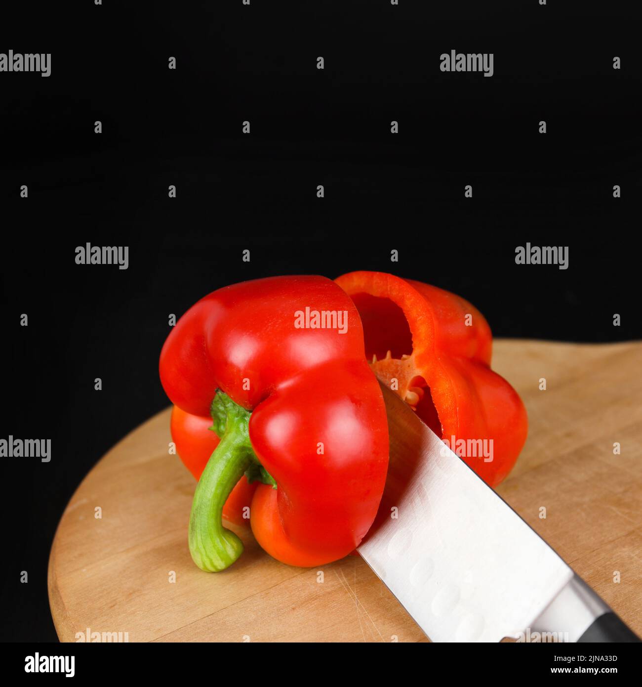 Knife cut the red pepper in kitchen on wooden board Stock Photo