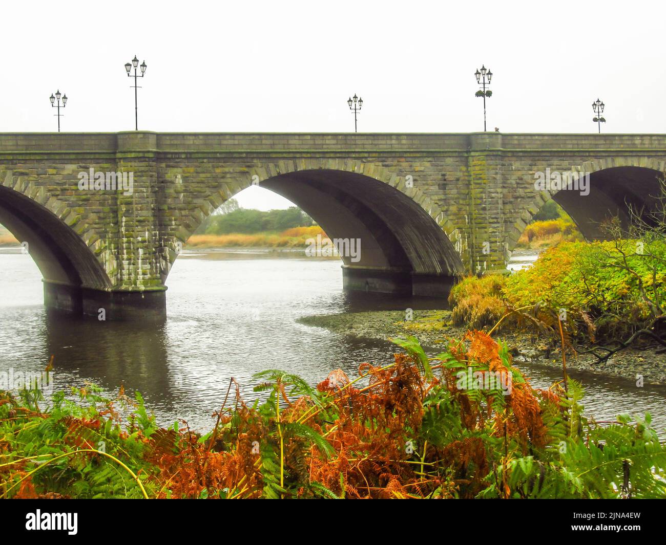 View of a stone bridge crossing the river Don in Aberdeen, Scotland on a cold rainy day. Stock Photo