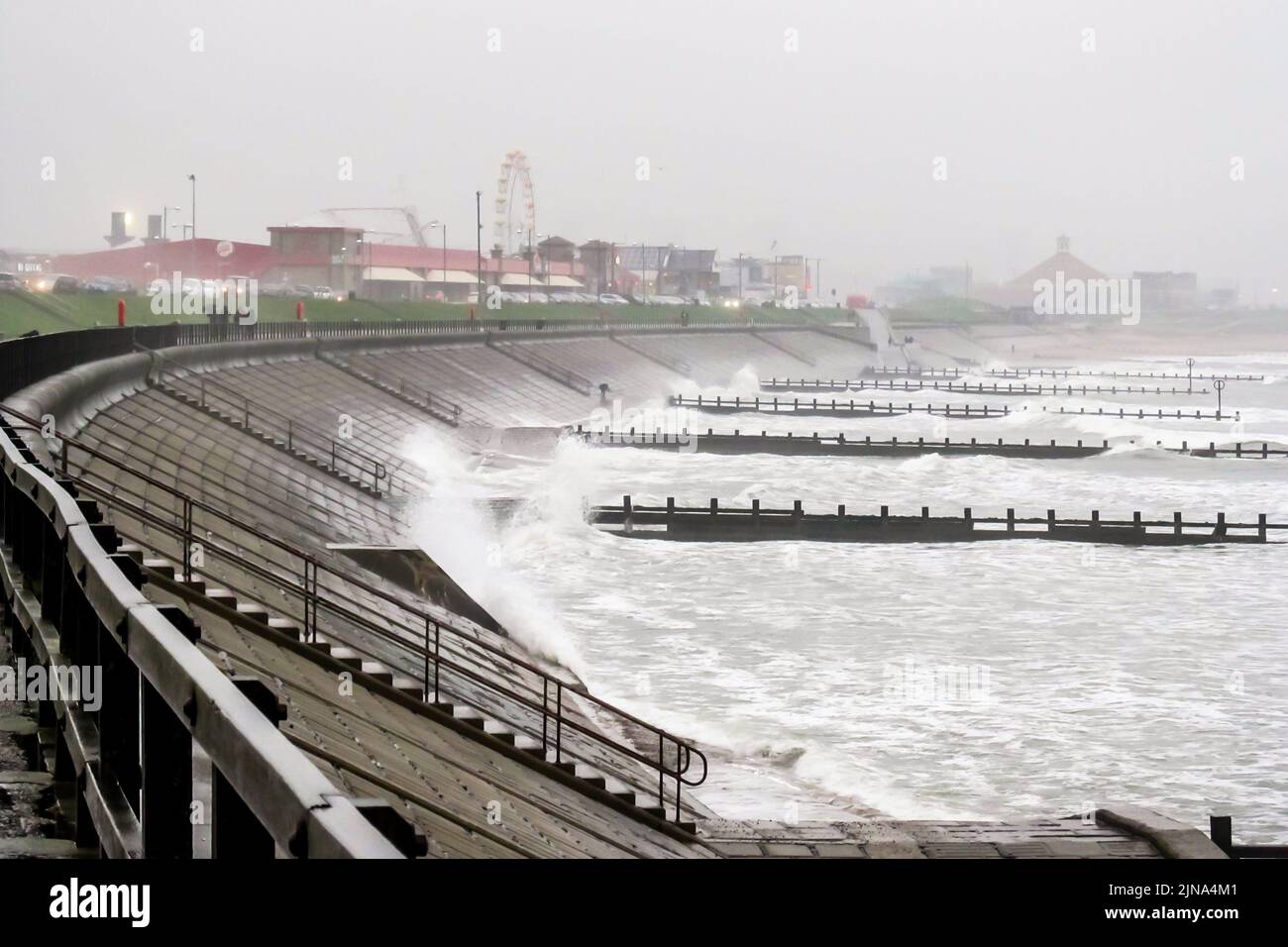 The Turbulent North Sea along the coast of Aberdeen, Scotland, with a fair in the distant in the mist. Stock Photo