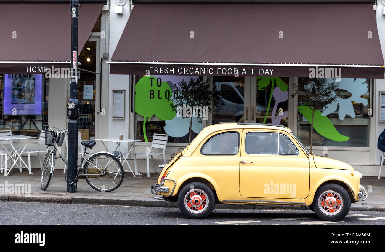 London, UK - 11 March 2022: Retro Fiat 500 parked outside of an organic cafe in the heart of Notting Hill, London. This district is a very popular tou Stock Photo