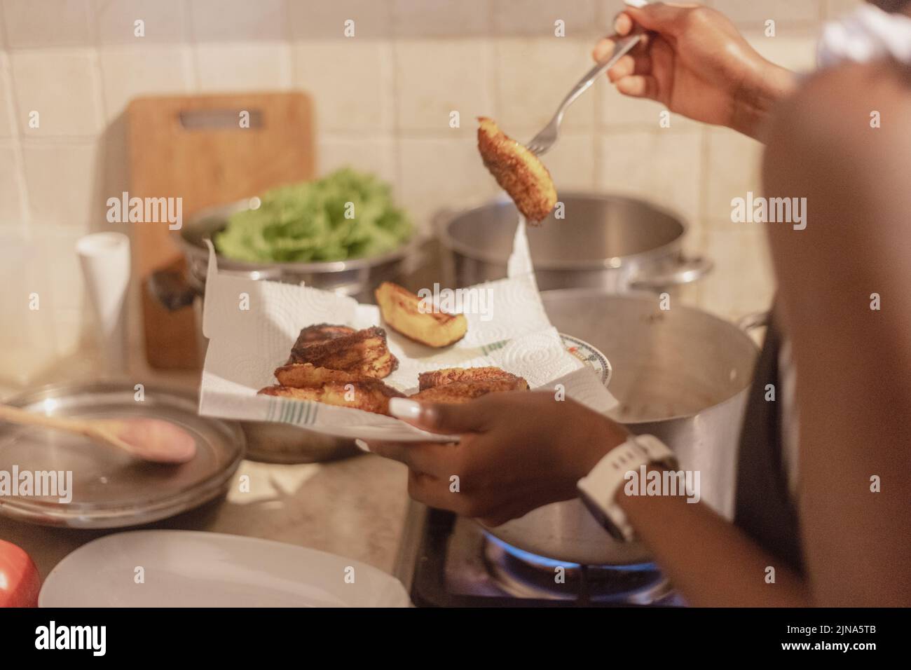 woman chef preparing african caribbean food with plantain plane tree fruit Stock Photo