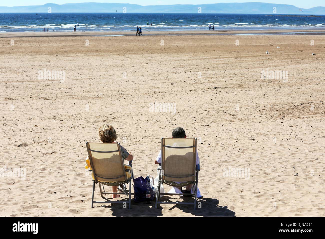 Saltcoats, UK. 10th Aug, 2022. As temperatures rise to mid 20's and the forecast is for warmer weather over the next 7 days, people take advantage of the sunny conditions by visiting Saltcoats beach. It is so warm that even the seagulls are bathing in the sea to cool down. Credit: Findlay/Alamy Live News Stock Photo