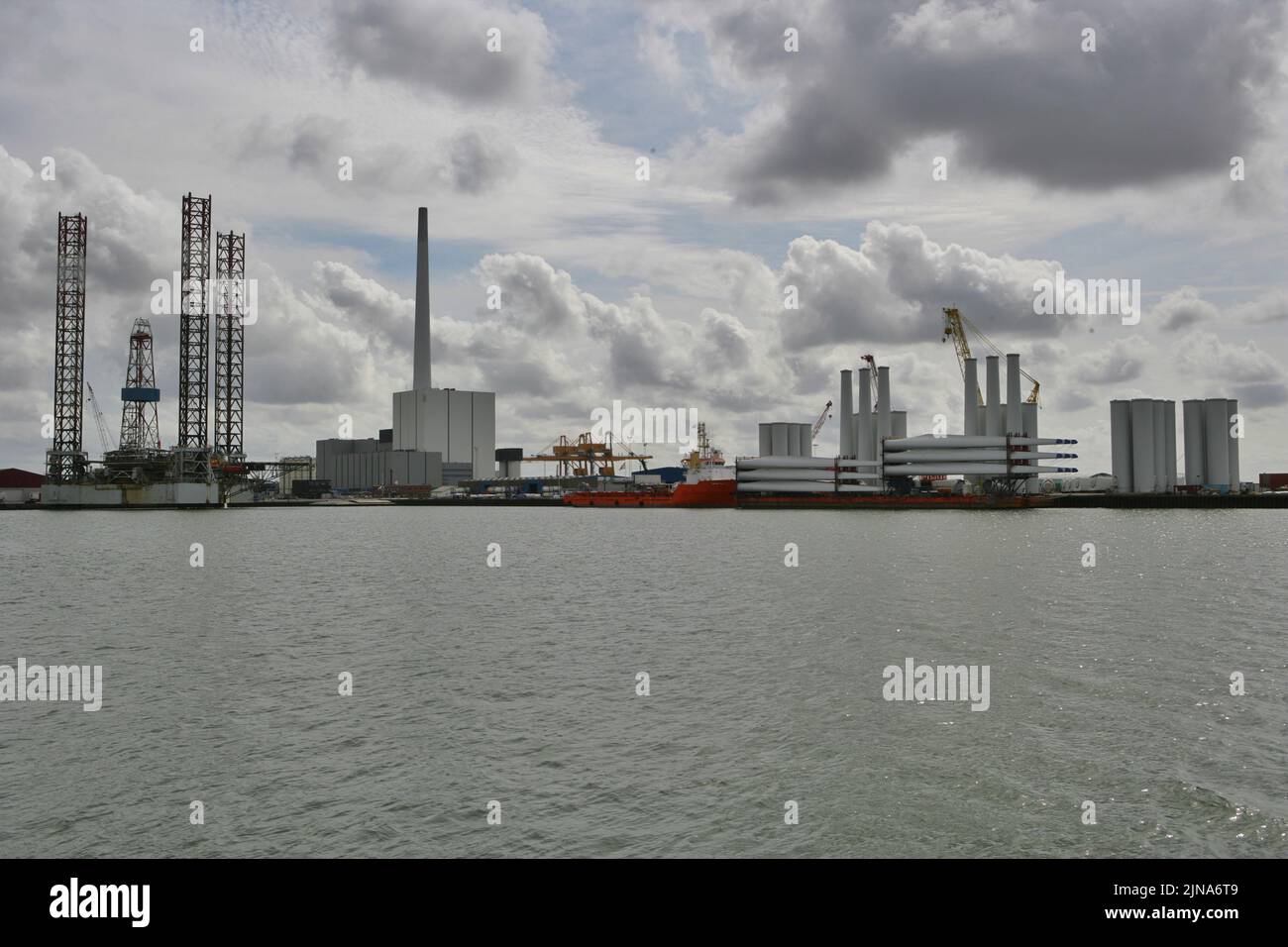 View of offshore oil rig and wind turbine components on the harbour dock, Esbjerg, Jutland, Denmark Stock Photo