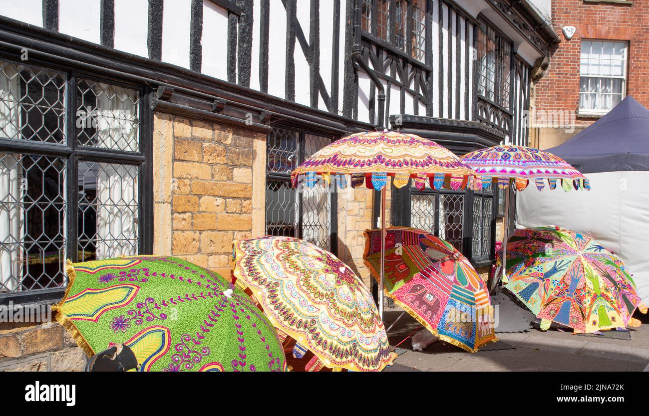 Umbrellas for sale outside a timber framed building, Sherborne market Stock Photo