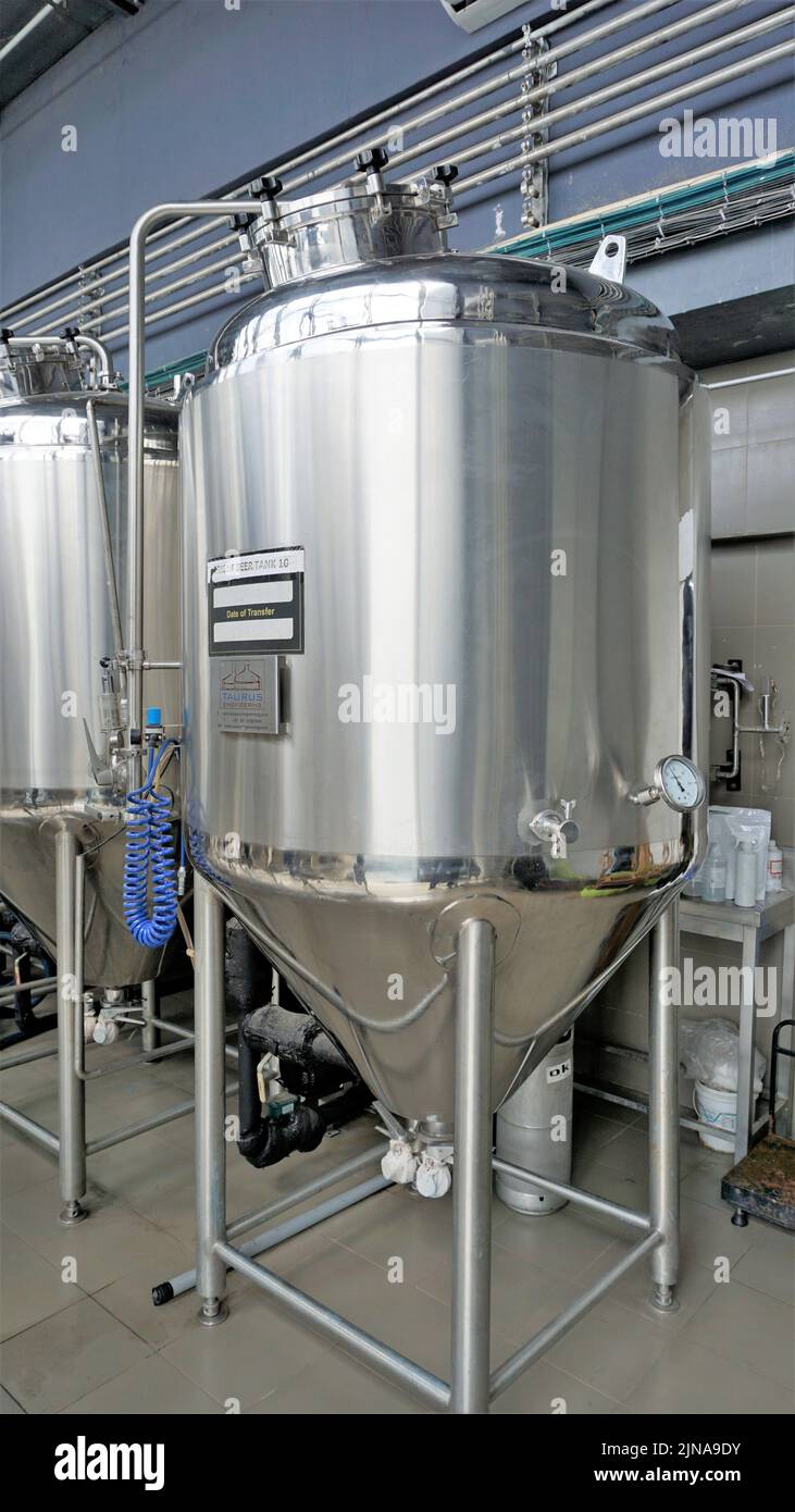 Row of shiny metal micro brewery tanks or Fermentation mash vats in