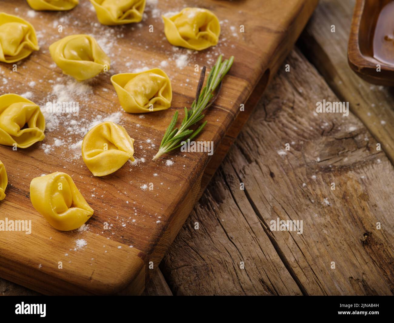 Appetizing homemade dumplings on a cutting board on a wooden background. High angle view. Recipes for home cooking. Recipe book, food blog. There are Stock Photo
