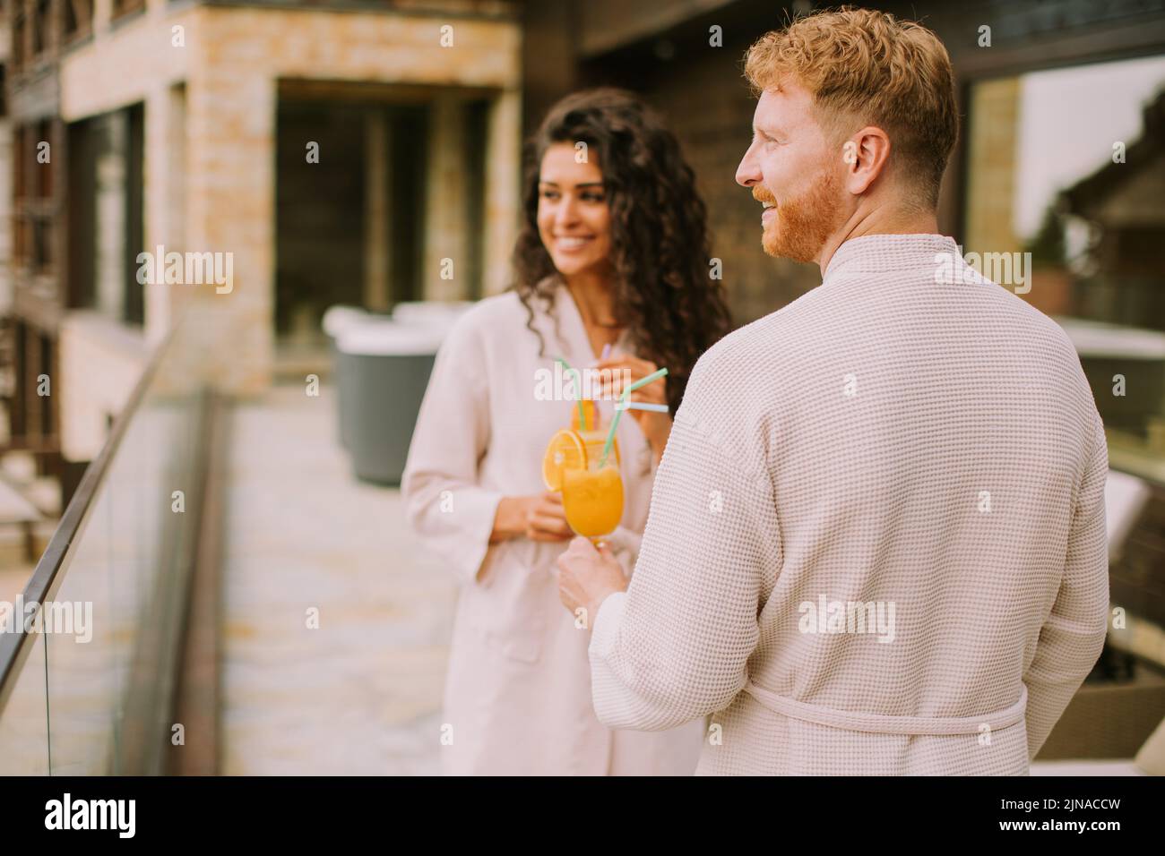 Handsome young  relaxing on  the outdoor terrace and drinking fresh orange juice Stock Photo