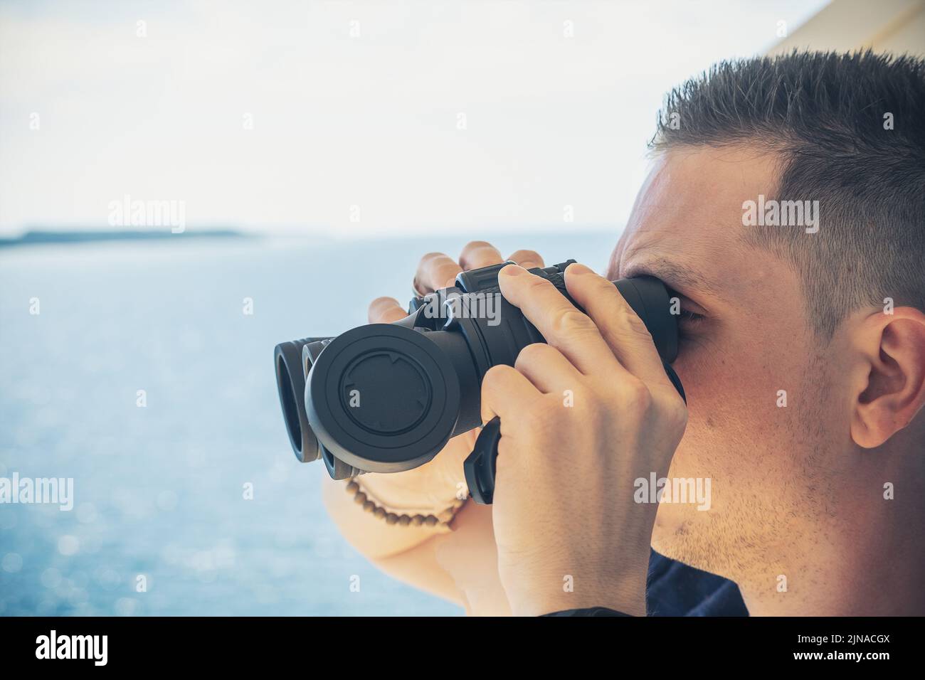 15 June 2021: Young Man Looking Through Binoculars On A Trip By Boat. Boat Trip With Binoculars Stock Photo