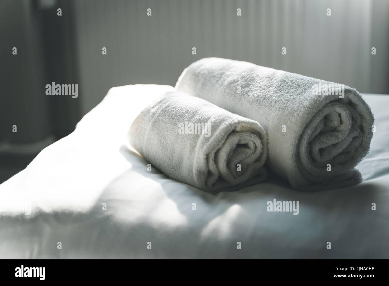 White Rolled Clean Towels On Hotel Bed Stock Photo