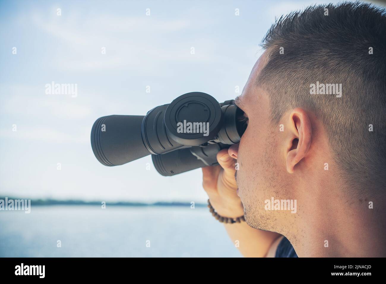 15 June 2021: Young Man Looking Through Binoculars On A Trip By Boat. Boat Trip With Binoculars Stock Photo