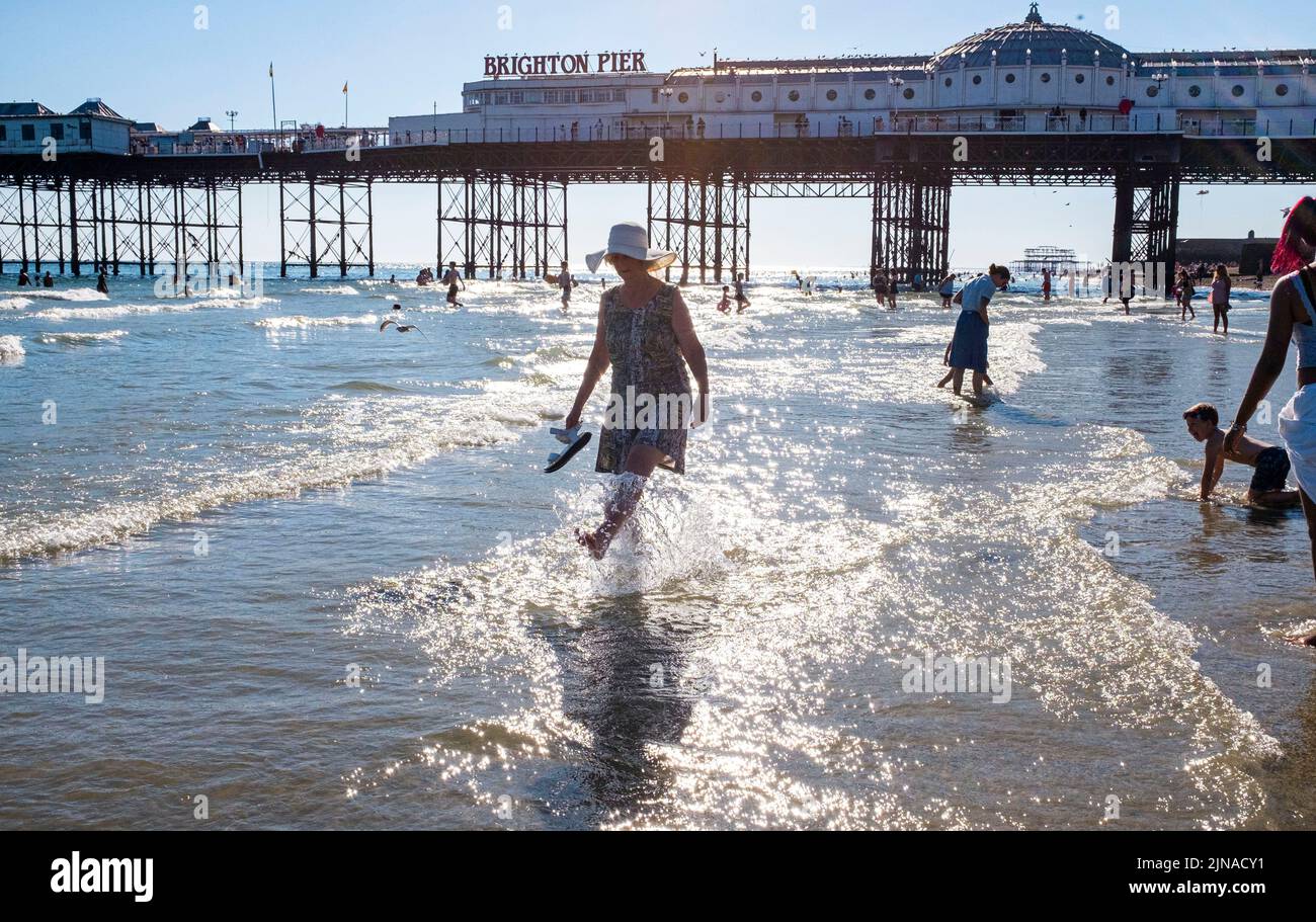 Brighton UK 10th August 2022 - Brighton Beach is packed with people at the end of a scorching hot sunny day as another heatwave begins with an amber warning being issued in parts of the South East  : Credit Simon Dack / Alamy Live News Stock Photo