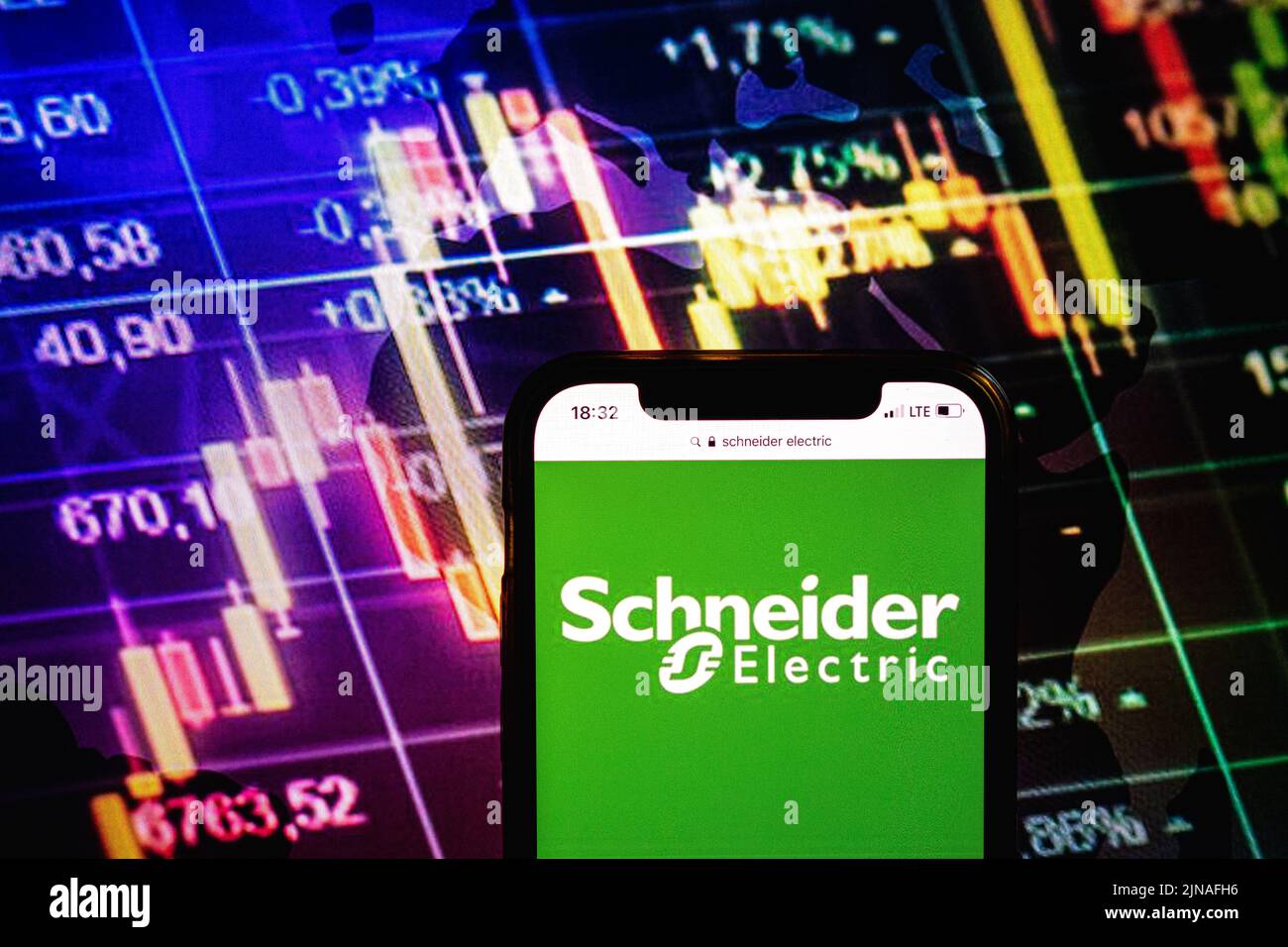 KONSKIE, POLAND - August 09, 2022: Smartphone displaying logo of Schneider Electric company on stock exchange diagram background Stock Photo