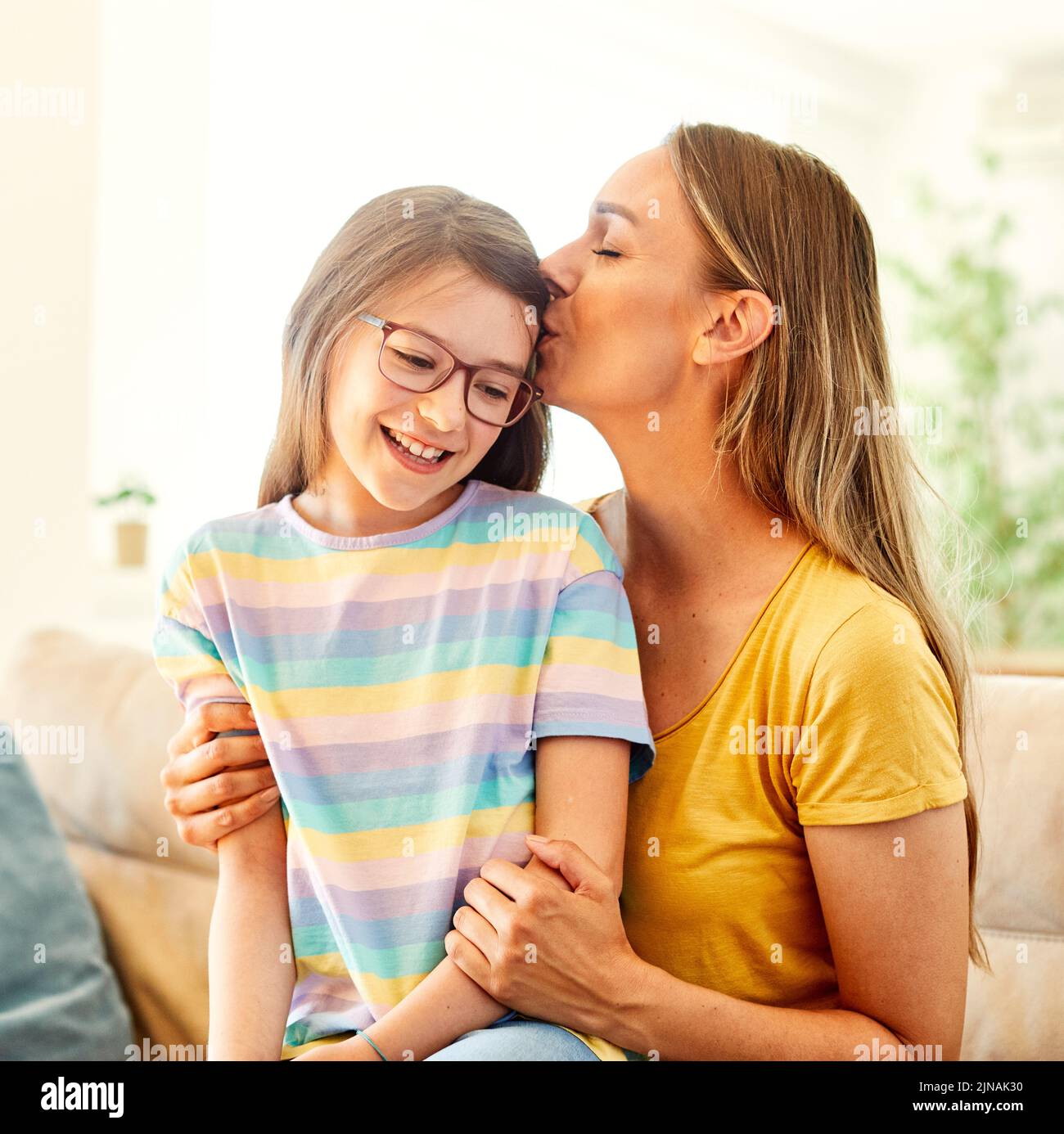 child mother family parent home woman happy playing daughter kid together indoor hug hugging kiss Stock Photo