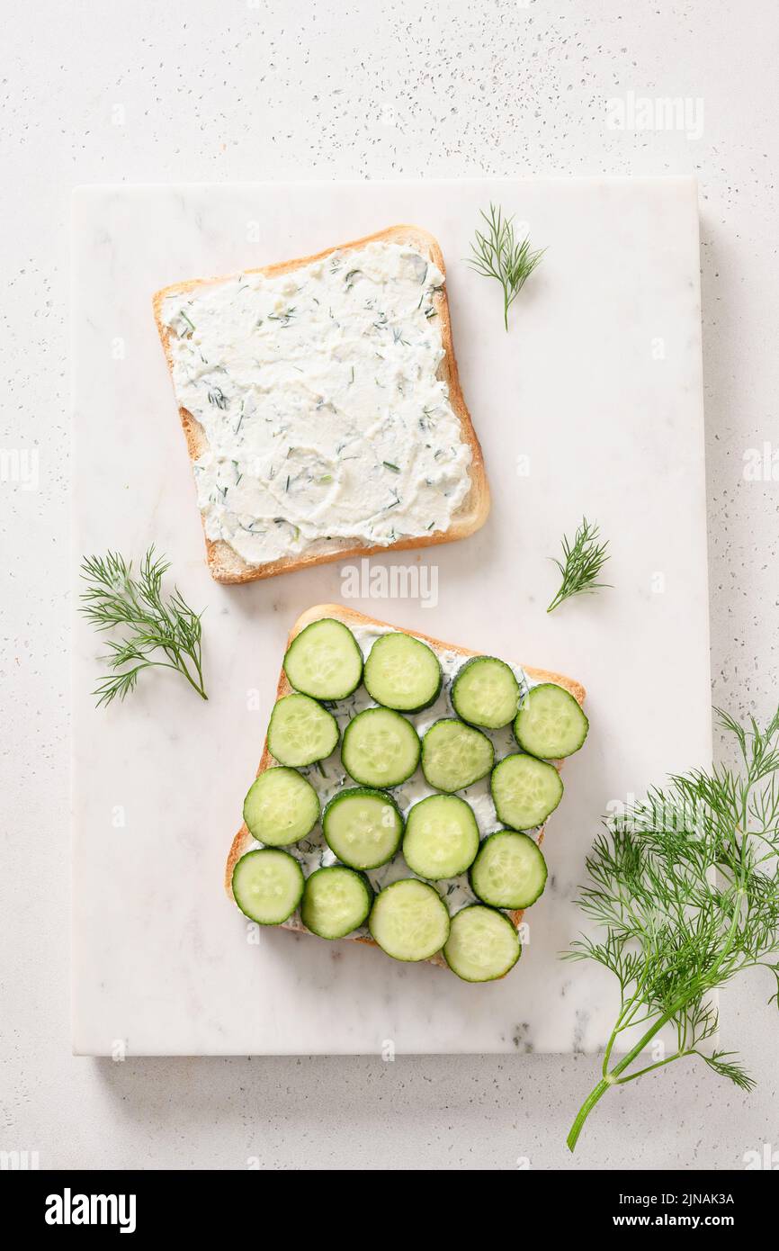 Cooking traditional English tea sandwiches with cucumber, cream cheese, dill for breakfast on
