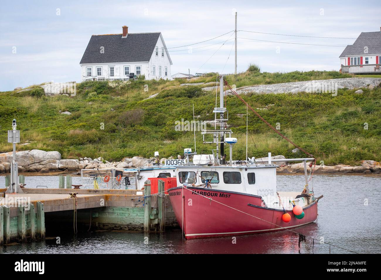 People walk around Peggy's Cove lighthouse in Peggy's Cove, Nova Scotia