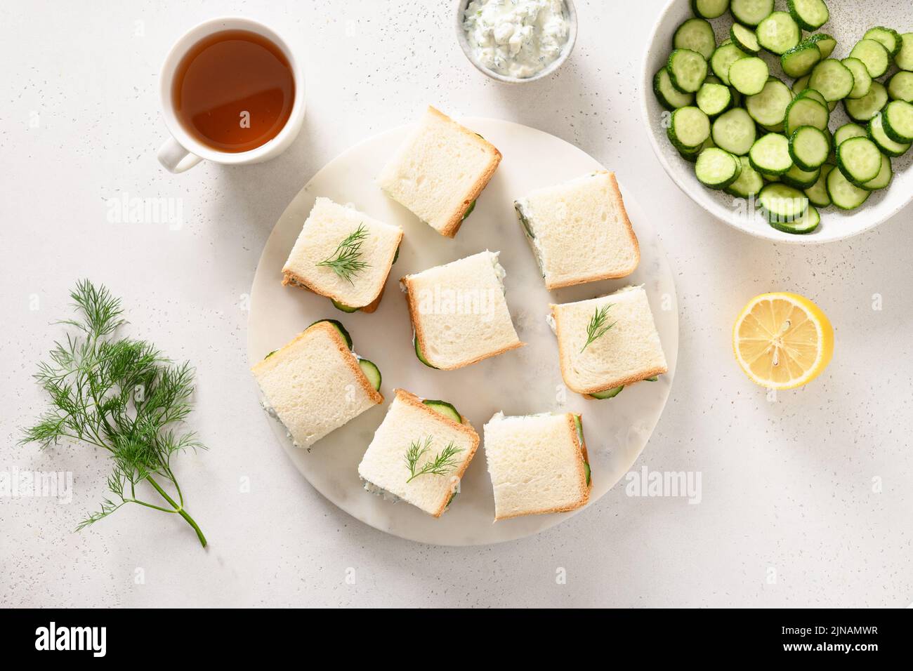 Cucumber sandwiches with ricotta and dill on white background. Top view