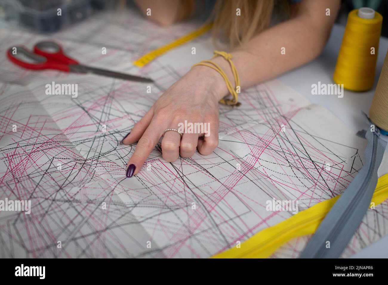 A clothing designer points out the details in a diecut sheet Stock