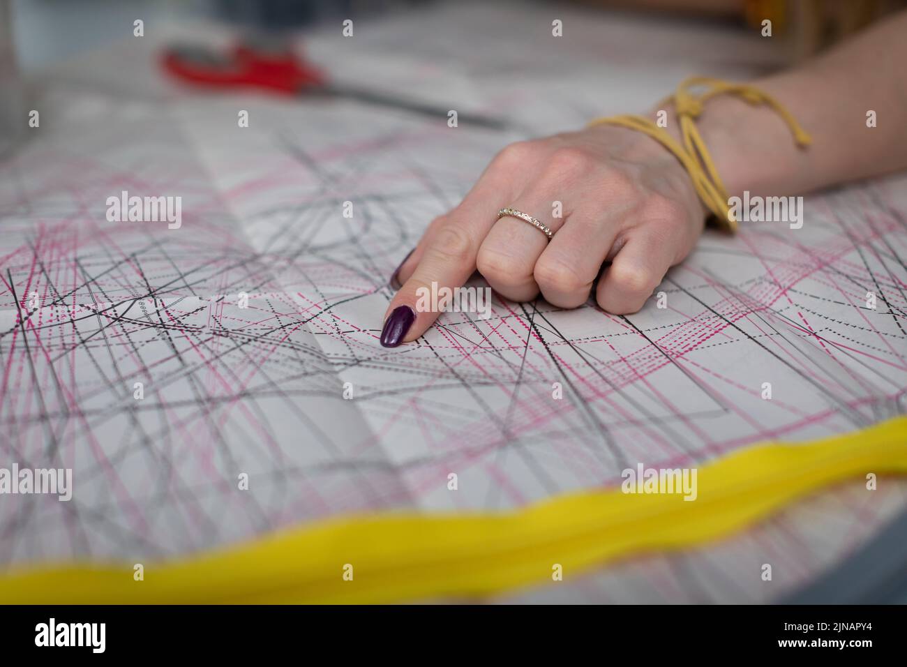 A clothing designer points out the details in a diecut sheet Stock