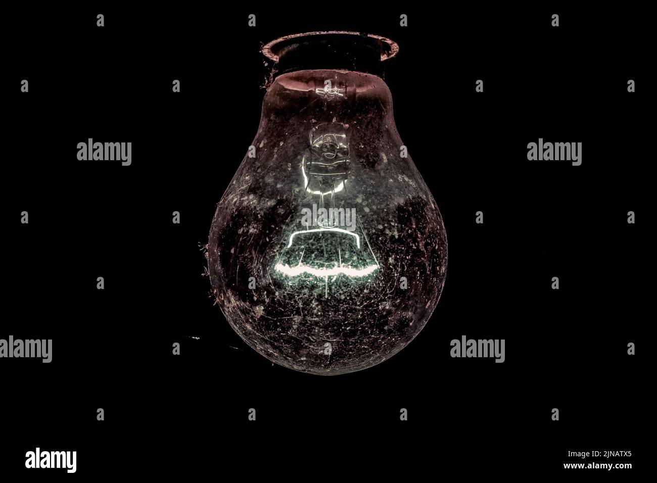 Tungsten light bulb lit on black background Stock Photo Alamy