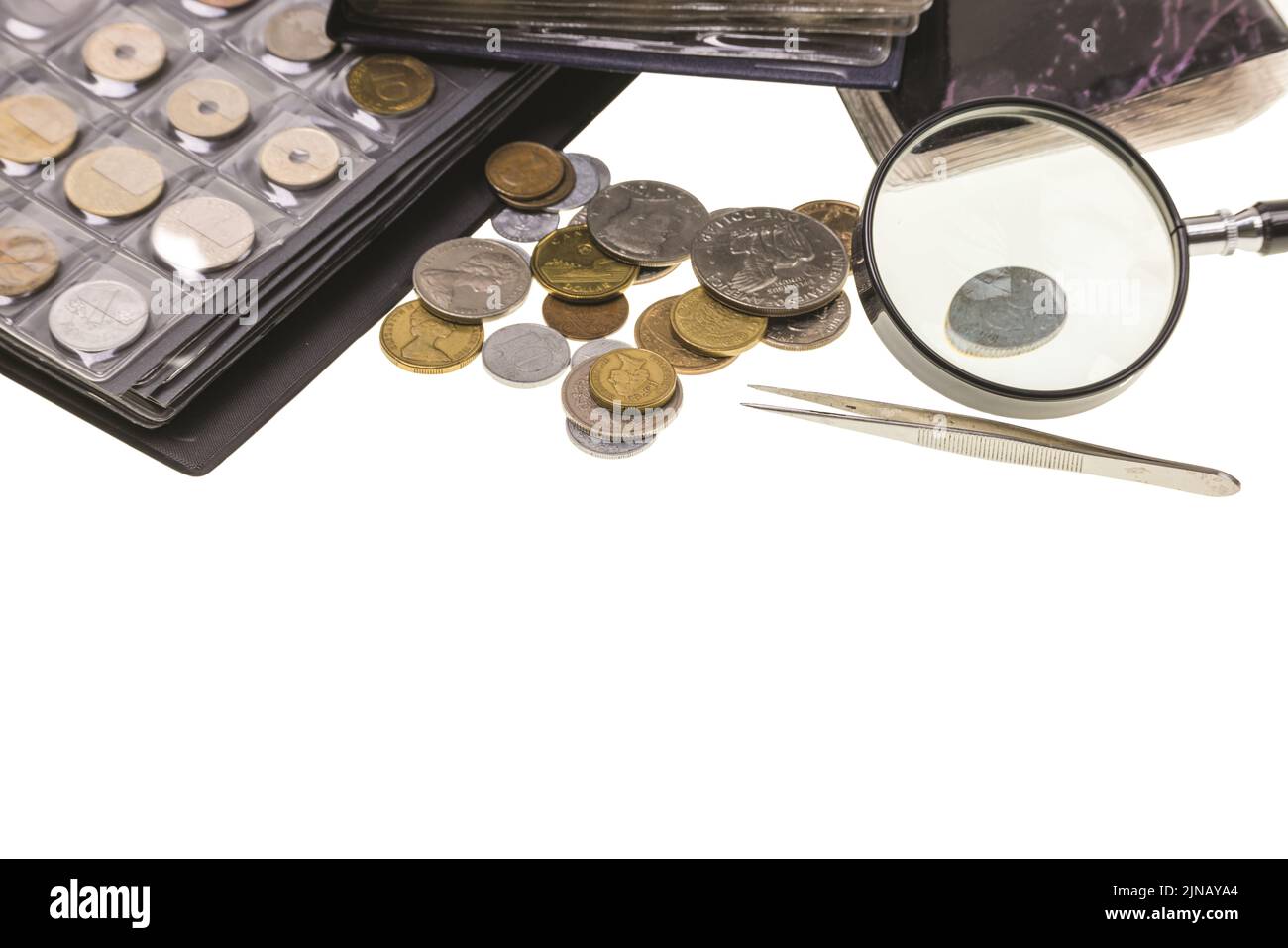 Magnifying Glass on the Pile of Coins on White Background Stock