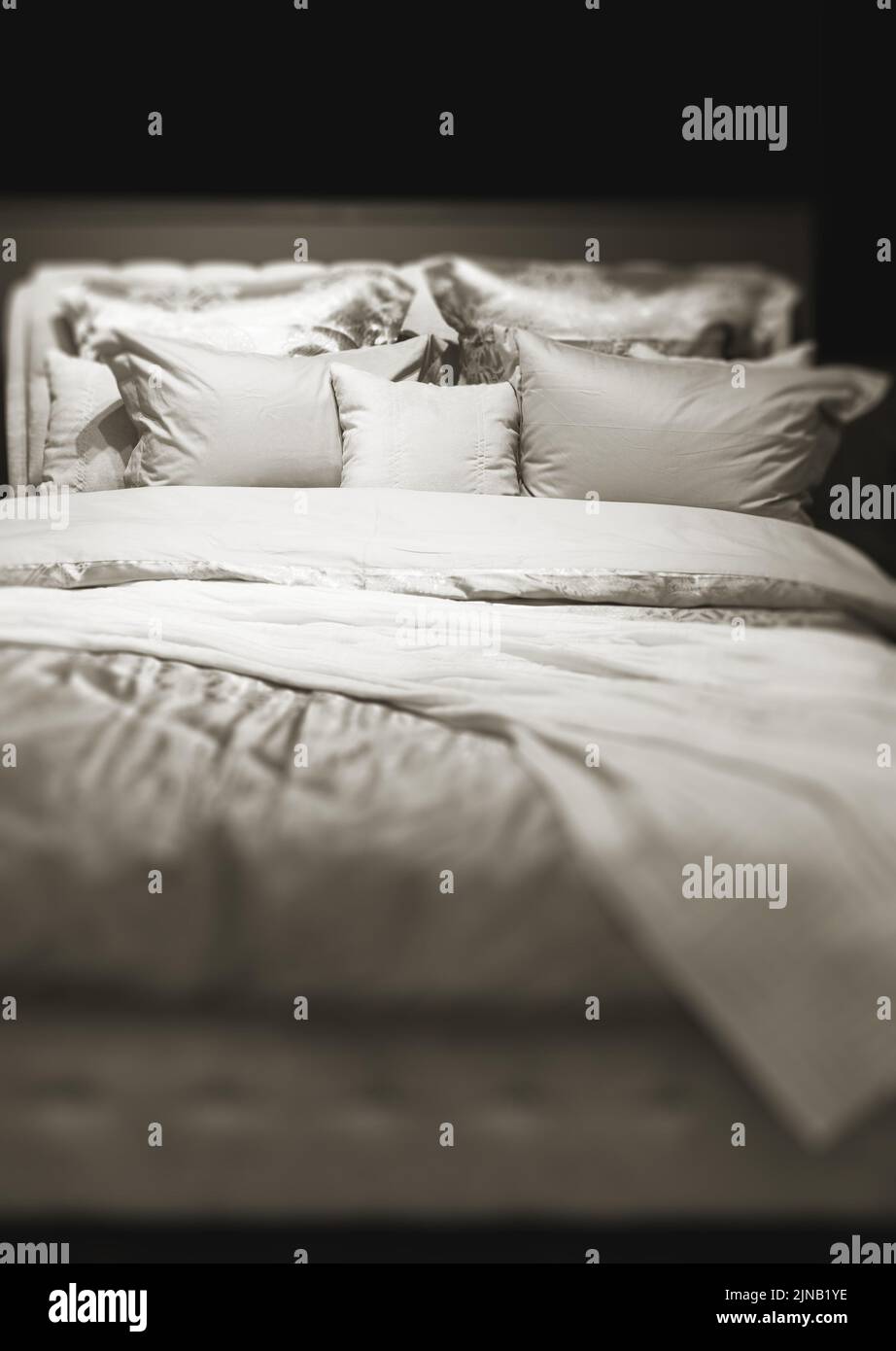 the double bed with bedclothes in dark Stock Photo