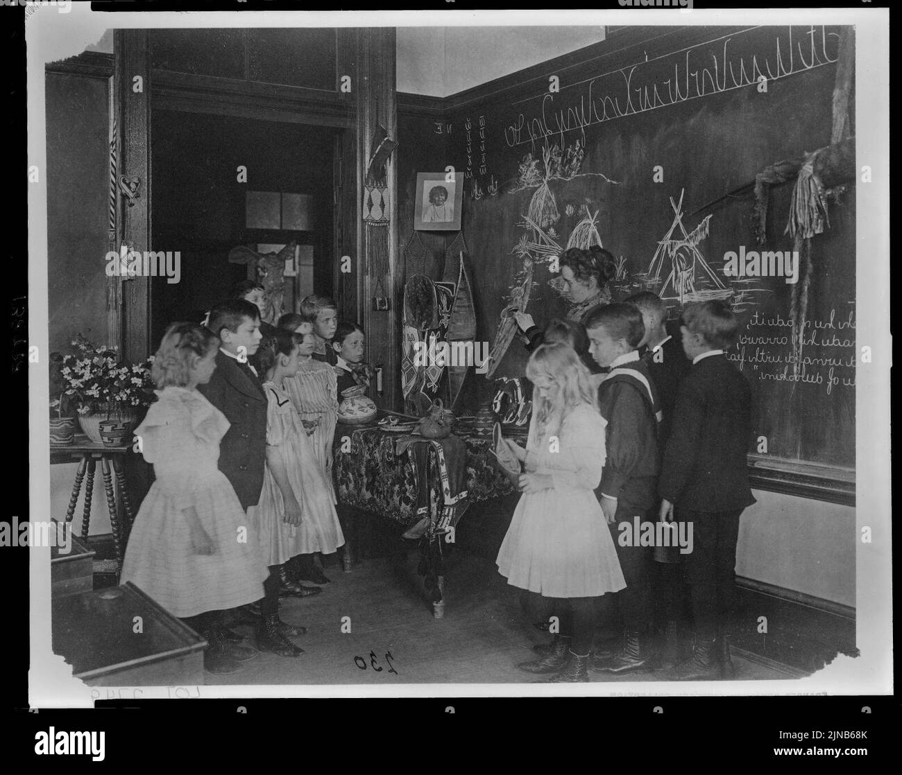 Teacher showing students Native American handicrafts at a school in ...