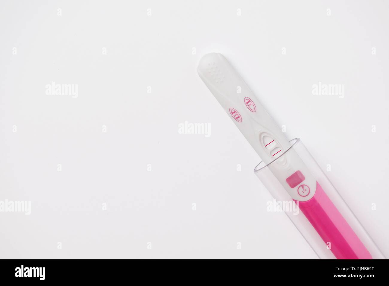 Positive pregnancy test with laboratory test tube. In vitro fertilization, artificial insemination and infertility treatment concept. Stock Photo