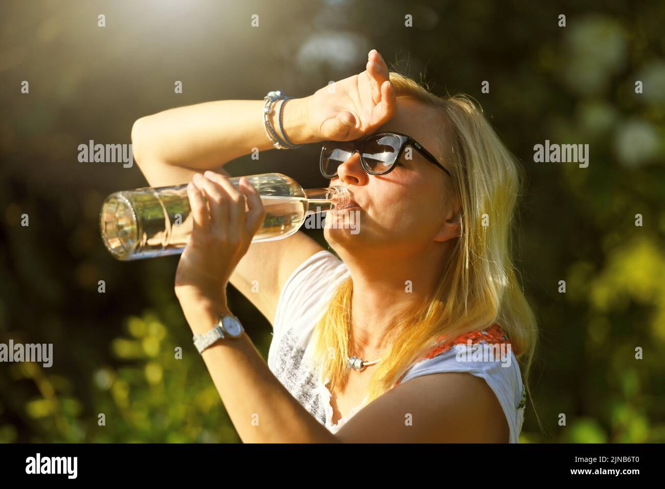 Woman In Garden Drinking Water From Bottle, Symbol Photo Heat Wave Stock Photo