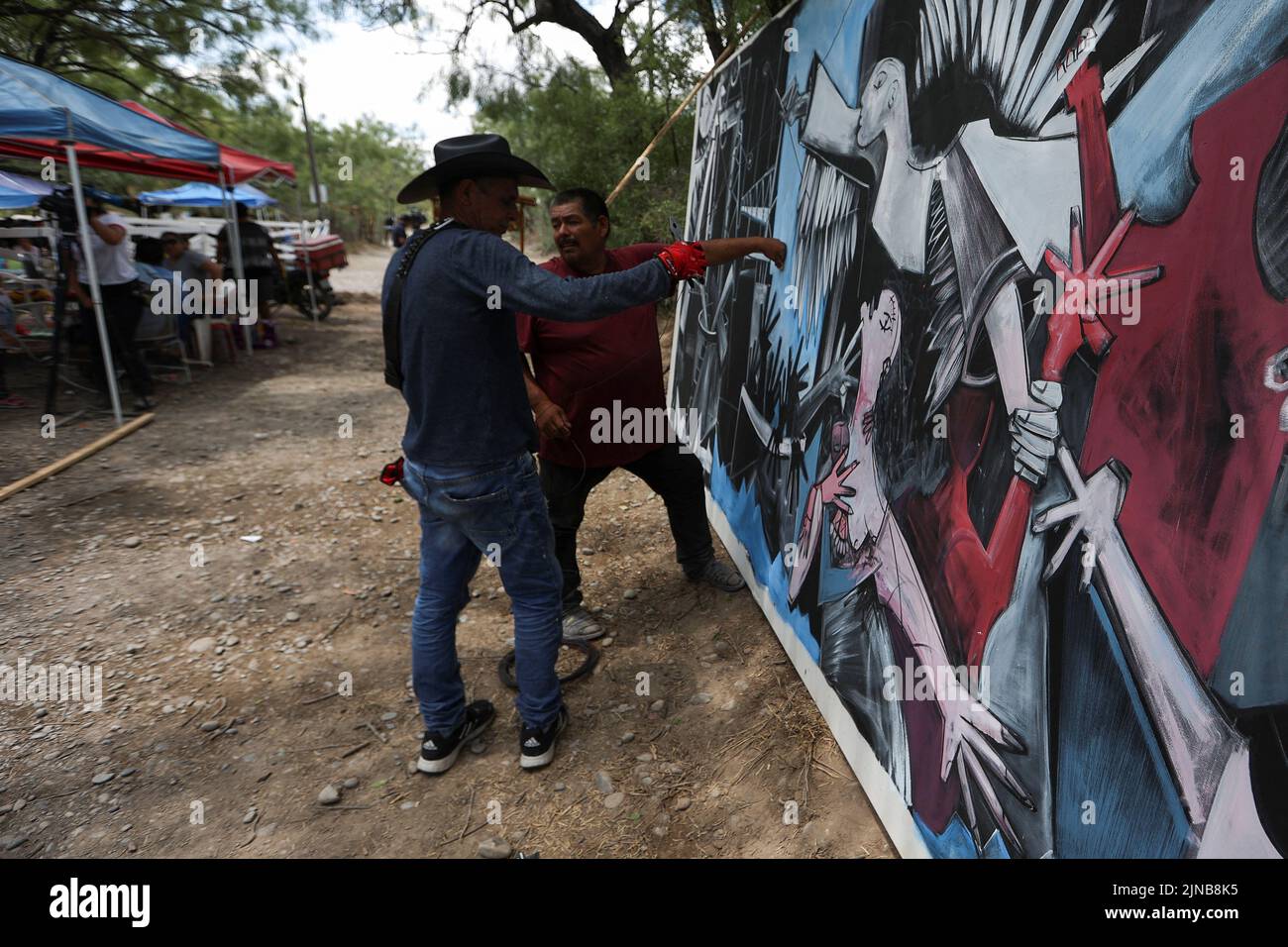 The painter Roberto Marquez works in a mural to give hope to the families of the miners trapped, in the area where they await news of their loved ones, outside the facilities of a coal mine where a mine shaft collapsed leaving miners trapped, in Sabinas, in Coahuila state, Mexico, August 10, 2022. REUTERS/Luis Cortes Stock Photo
