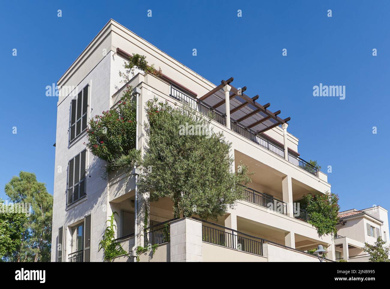 Modern residential building with plants and trees. Stock Photo