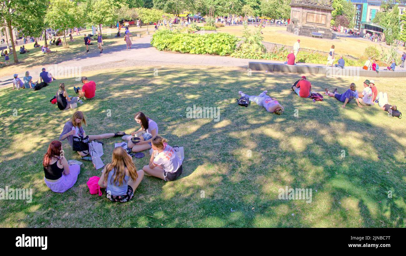 Edinburgh, Scotland, UK  10th August,  2022. UK Weather: St Andrews Square, Sunny weather on the way saw locals and tourists toast in the sun as the grass on princes street gardens burned and  they took in the acts and flyer chuckers on the royal mile and mound. Credit Gerard Ferry/Alamy Live News Stock Photo